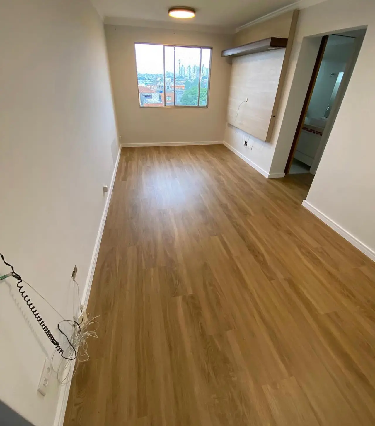 Living amplo integrado com sala de jantar e piso laminado elegante