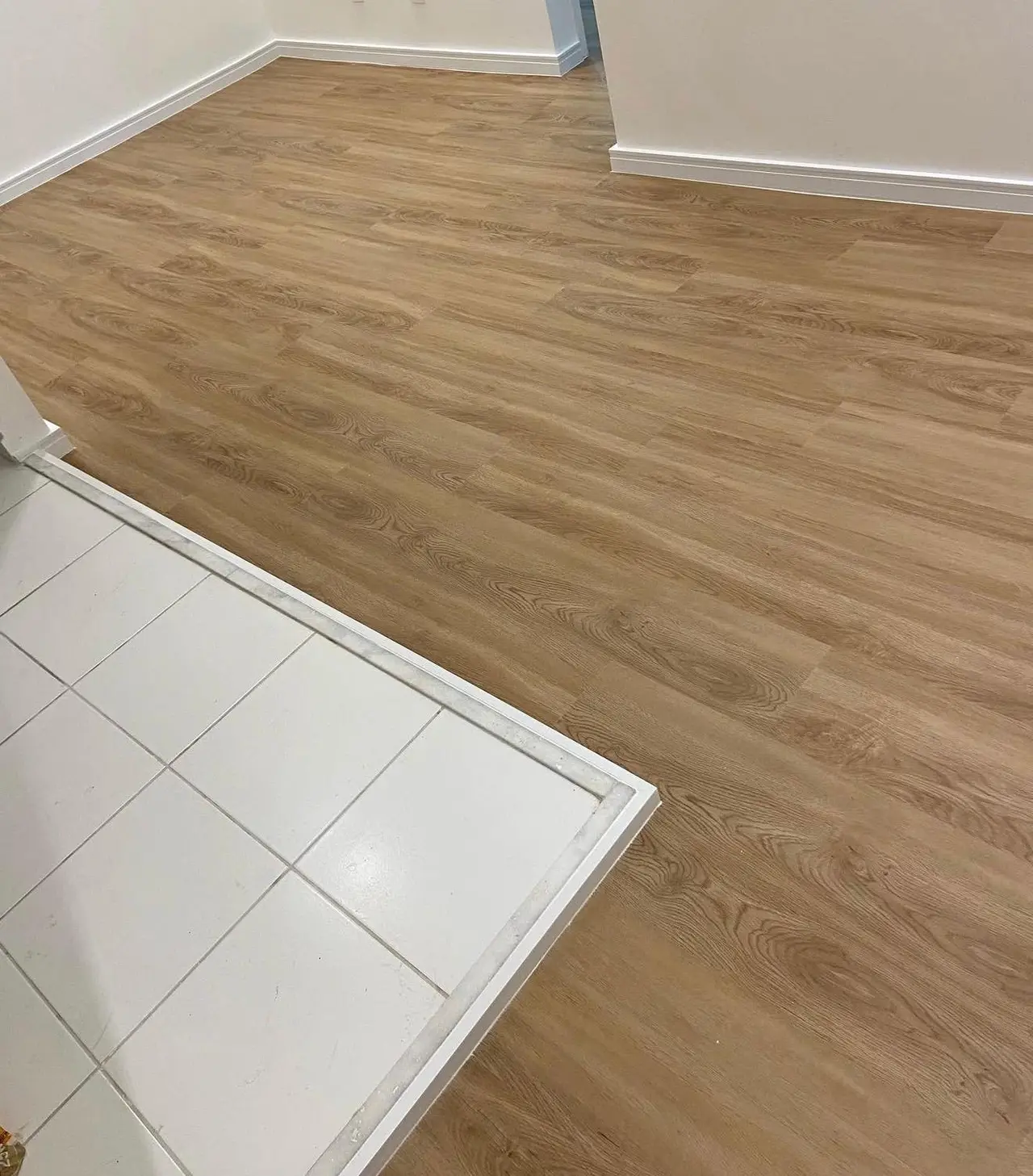 Sala de estar ampla e iluminada com piso laminado amadeirado claro